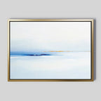 Distant Archipelago Canvas Art - Horizontal: Minimalist gold-framed wall art showcasing a tranquil seascape with light and dark blue water, a thin sandy shore, and soft sky—ideal for contemporary wall decor on a plain gray background.