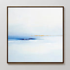 The Distant Archipelago Canvas Art - Square features soft blue and white tones with a touch of orange near the horizon, evoking a tranquil seascape. This contemporary piece has a slim dark frame and is shown on a light-colored wall.