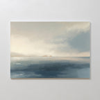 Distant Isles Canvas Art - Horizontal features a serene seascape with hazy islands and a soft cloudy sky in muted blue and beige tones, bringing tranquil home decor to any space.