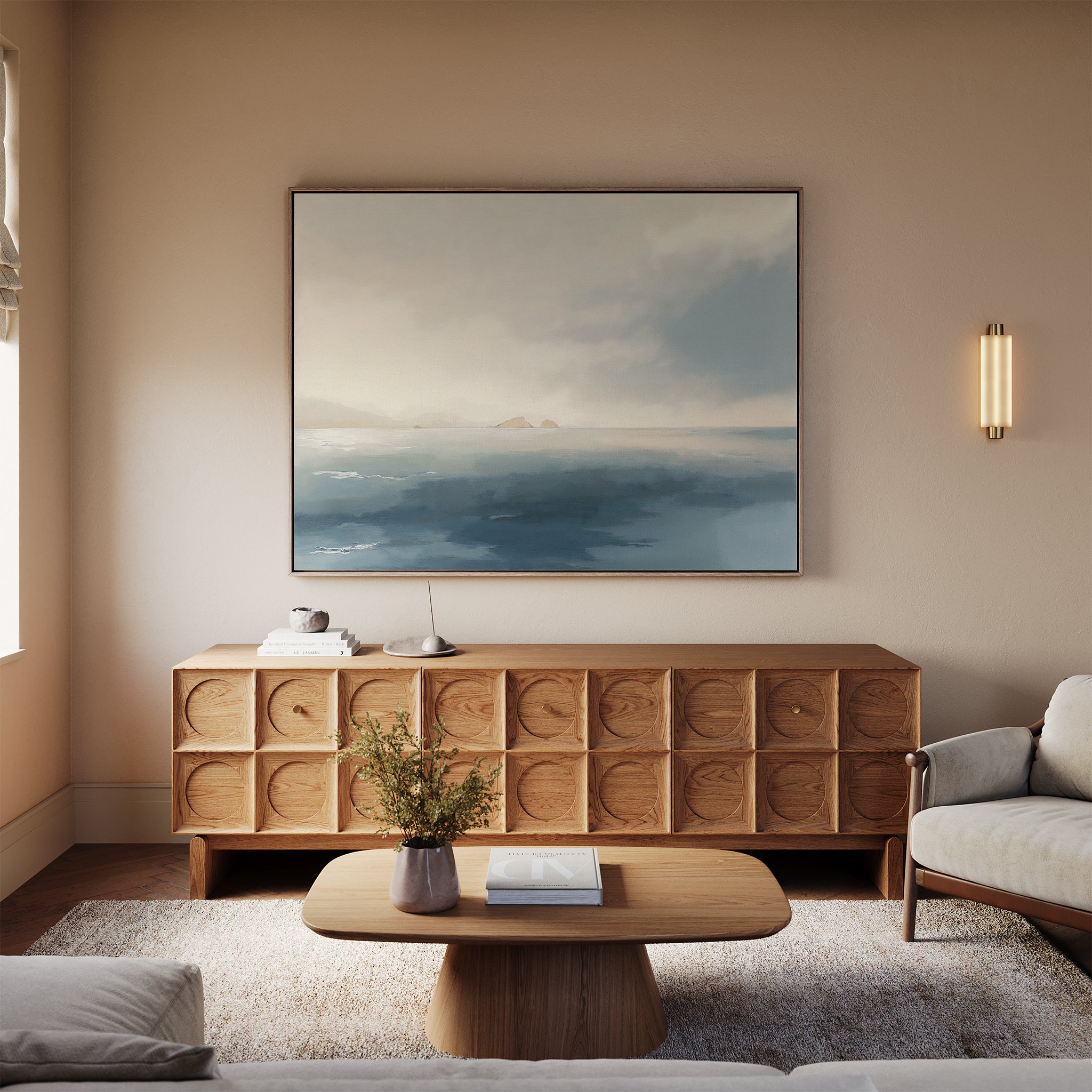 A cozy living room showcases a wooden coffee table, geometric-patterned sideboard, beige sofa, and tranquil decor including the Distant Isles Canvas Art - Horizontal above the sideboard. A vase with flowers completes the inviting space.
