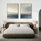 A modern bedroom features a green upholstered bed with white bedding, two gold nightstands with pleated lamps, and "Distant Isles - Set of 2" canvas prints above the bed. A textured rug adds warmth to the floor.