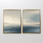 The "Distant Isles - Set of 2" features two framed paintings side by side, creating a seamless coastal canvas print with serene blue water, distant mountains, and a soft cloudy sky for a tranquil atmosphere.