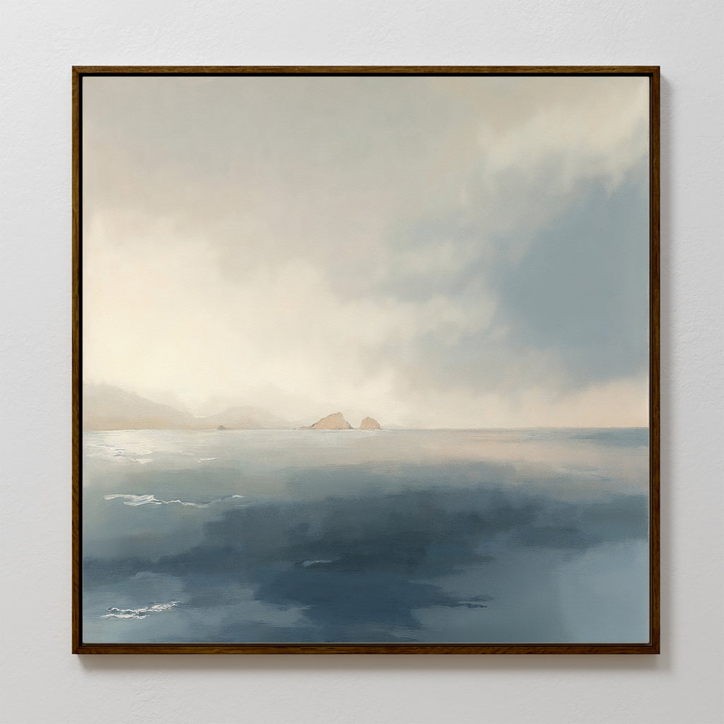 The Distant Isles Canvas Art - Square features a serene seascape with gentle waves, distant mountains, and two rocky islands under a cloudy sky. Soft blue and gray tones create a peaceful, calming ambiance for your wall décor.