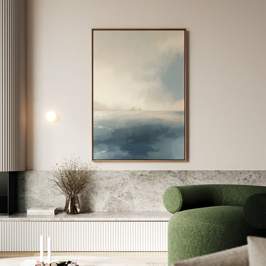 A modern living room showcases the Distant Isles Canvas Art - Vertical above a marble shelf, paired with a green curved sofa, dried flowers in a vase, and soft neutral accents for a tranquil, inviting atmosphere.