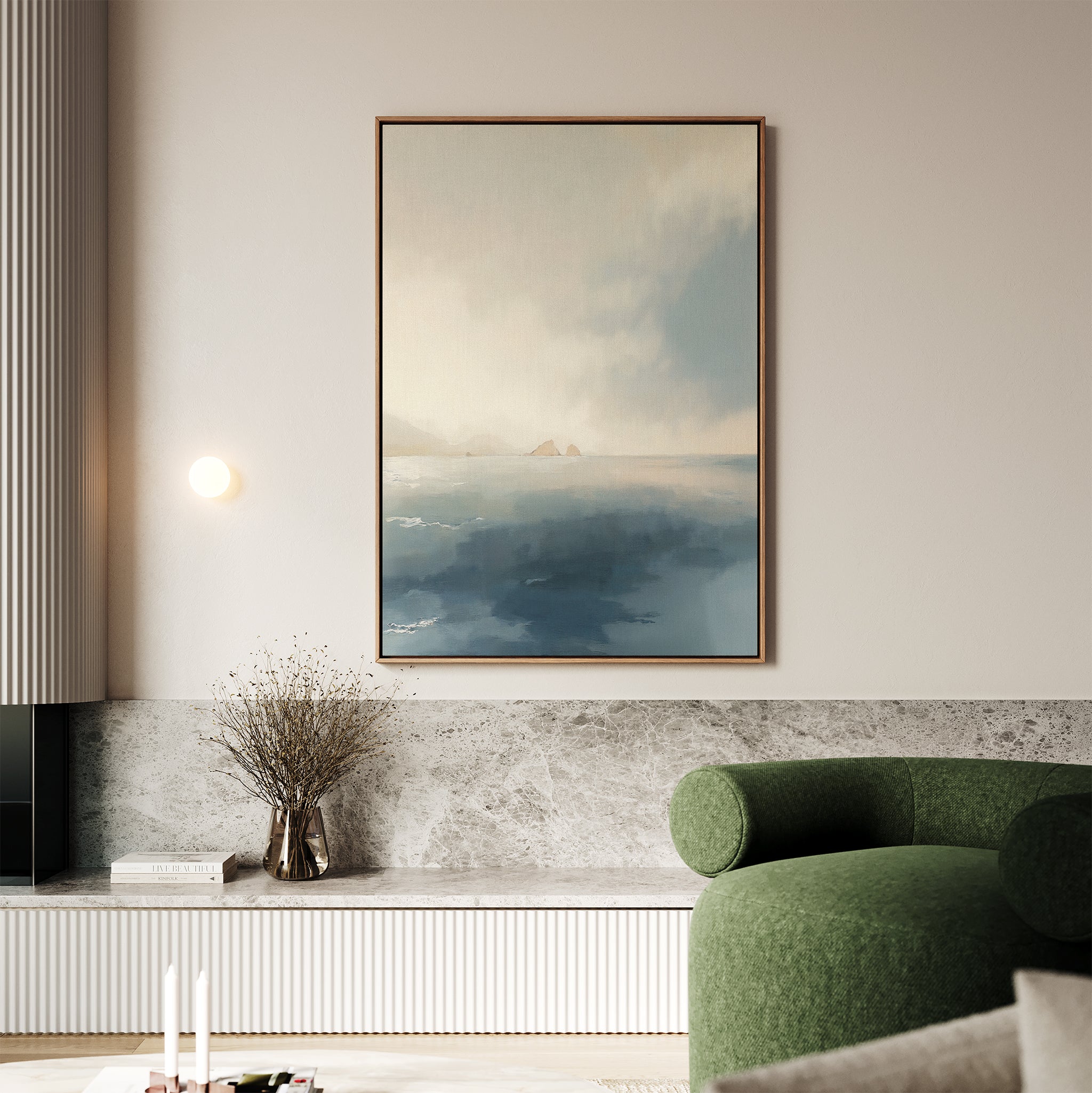 A modern living room showcases the Distant Isles Canvas Art - Vertical above a marble shelf, paired with a green curved sofa, dried flowers in a vase, and soft neutral accents for a tranquil, inviting atmosphere.