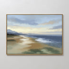 The Distant Shores Canvas Art - Horizontal features a tranquil beach with gentle waves, sandy shore, mountains, and pastel clouds at sunrise or sunset, displayed on a plain white wall.