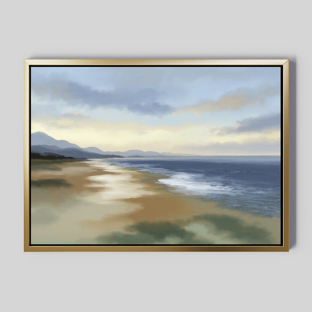 The Distant Shores Canvas Art - Horizontal features a framed painting of a tranquil coast with calm waves, a sandy beach, and distant mountains beneath a cloudy sky in soft, muted tones.