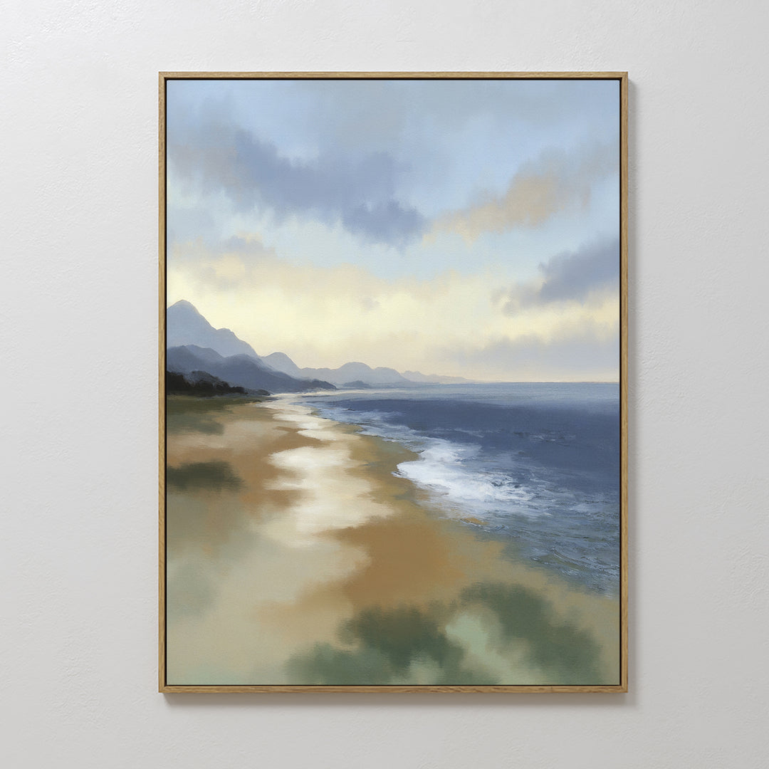 The Distant Shores Canvas Art - Vertical features a tranquil beach with gentle waves, sandy shore, distant mountains, and a partly cloudy sky, elegantly framed and displayed on a white wall.