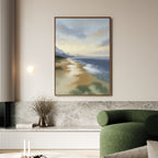 A modern living room features a green curved sofa, marble accent wall, and the Distant Shores Canvas Art - Vertical hanging over a minimalist console. A round wall light and dried flowers in a vase complete the look.