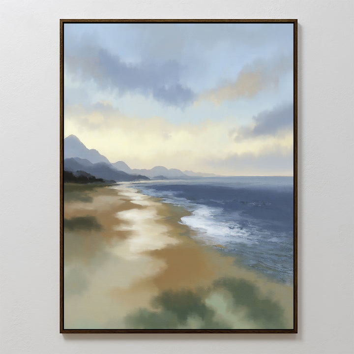 The Distant Shores Canvas Art - Vertical features a serene coastal panorama with gentle waves, sandy shore, distant mountains, and a cloudy sky at sunrise or sunset, beautifully framed and displayed on a plain white wall.