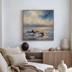 A modern living room with a beige sofa, wooden sideboard, ceramic vases, and the Dolphin Pod at Sunset Canvas Art - Square featuring dolphins swimming in the ocean beneath a dramatic, colorful sky.