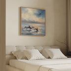 A cozy, neutral-toned bedroom with a beige bed and white pillows features the "Dolphin Pod at Sunset Canvas Art - Square" above the bed, showcasing dolphins swimming under a colorful, cloudy sky.