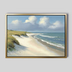 The Dune Whispers Canvas Art - Horizontal displays a sandy beach, grassy dunes, soft waves, and a blue sky with clouds, elegantly mounted on a plain light gray wall.