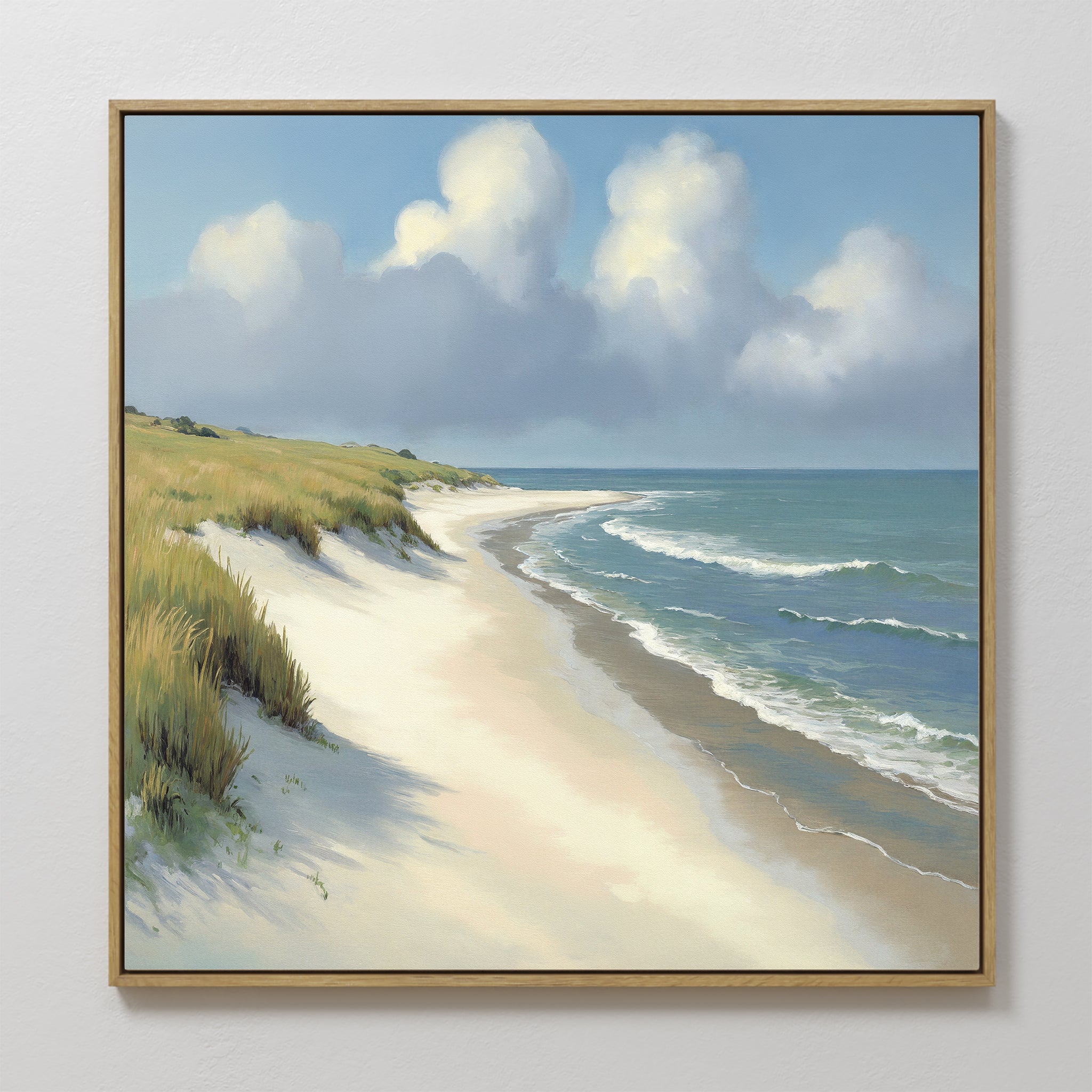 The Dune Whispers Canvas Art - Square features a framed print of a sunlit sandy beach with gentle waves, grassy dunes on the left, and a blue sky with fluffy white clouds—a calm, serene coastal landscape.