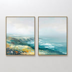 The "Emerald Cliffs - Set of 2" features framed canvas prints side by side, showing an abstract coastal landscape with emerald cliffs, blue ocean waves, and yellow highlights beneath a cloudy sky in soft, muted tones.