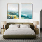 A modern bedroom with an olive-green bed, white bedding, beige nightstands with matching lamps, and the Emerald Cliffs - Set of 2 coastal landscape canvas prints above the bed. A textured rug covers the floor.