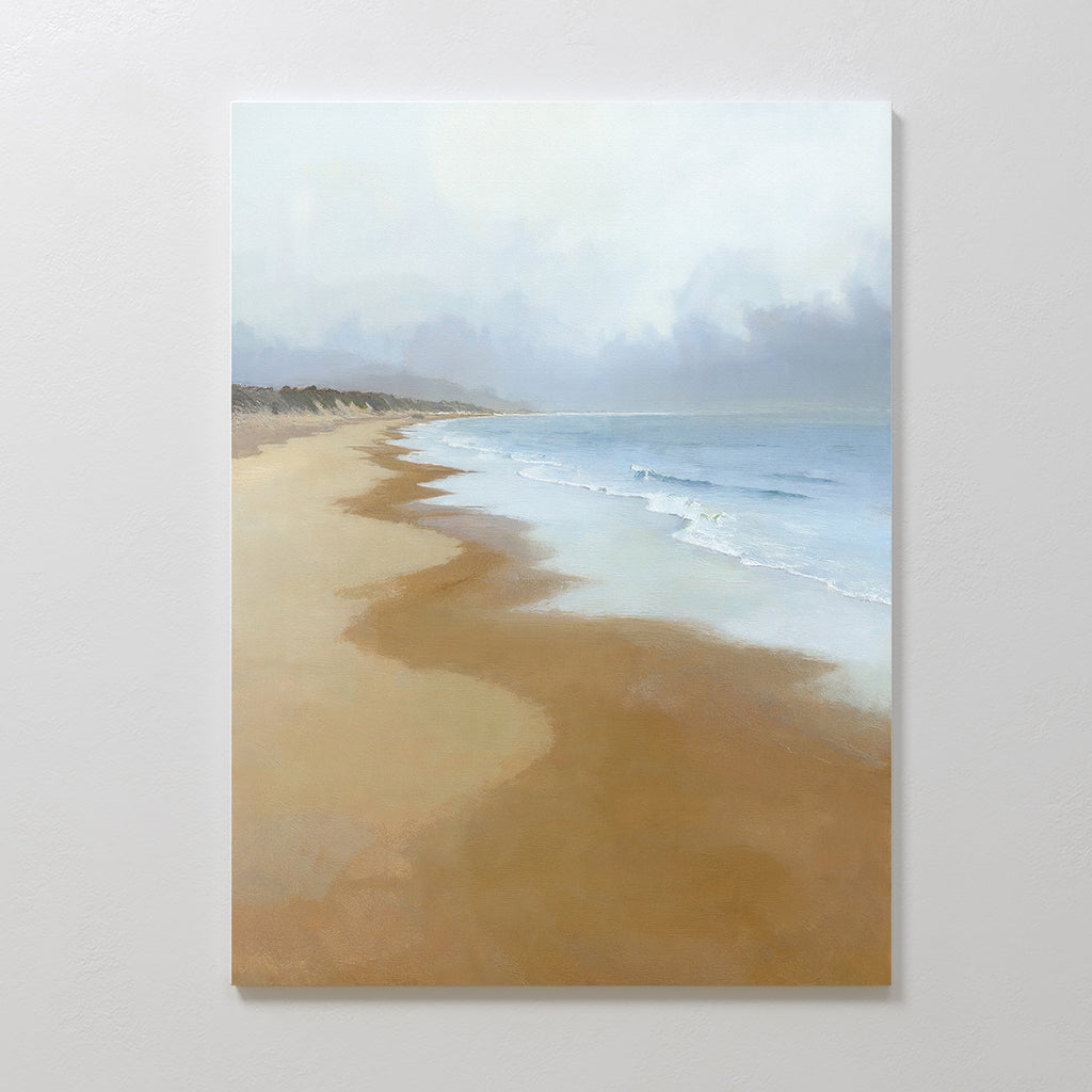 The Endless Shoreline Canvas Art - Vertical features a serene beach with gentle waves, a misty horizon, and wet sand reflecting a soft cloudy sky—perfect as calming wall art to bring peaceful coastal vibes to any space.