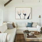 A cozy living room with white shiplap walls, a large white sectional sofa with assorted throw pillows, a rustic wooden coffee table, and the Ethereal Blooms Canvas Art - Horizontal above the sofa—perfect for modern spaces.