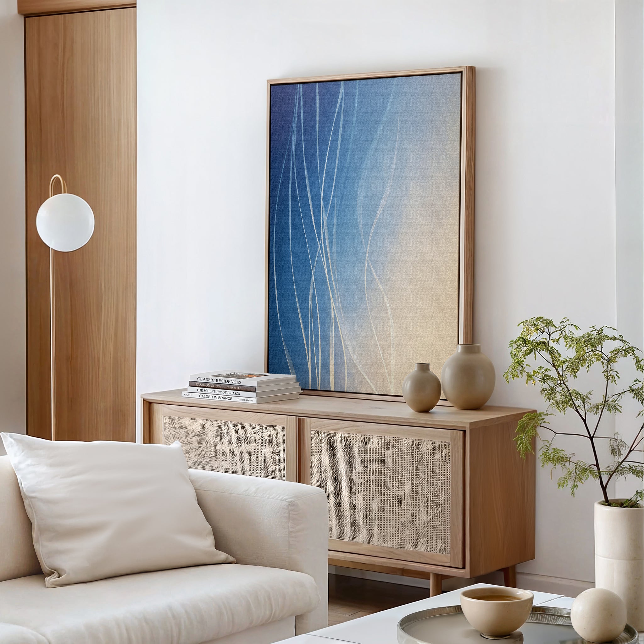 A modern living room featuring the Ethereal Lines Canvas Art - Vertical, a light wood sideboard, decorative vases, a round lamp, and Nordic Park style—ideal for those seeking refined modern decor.