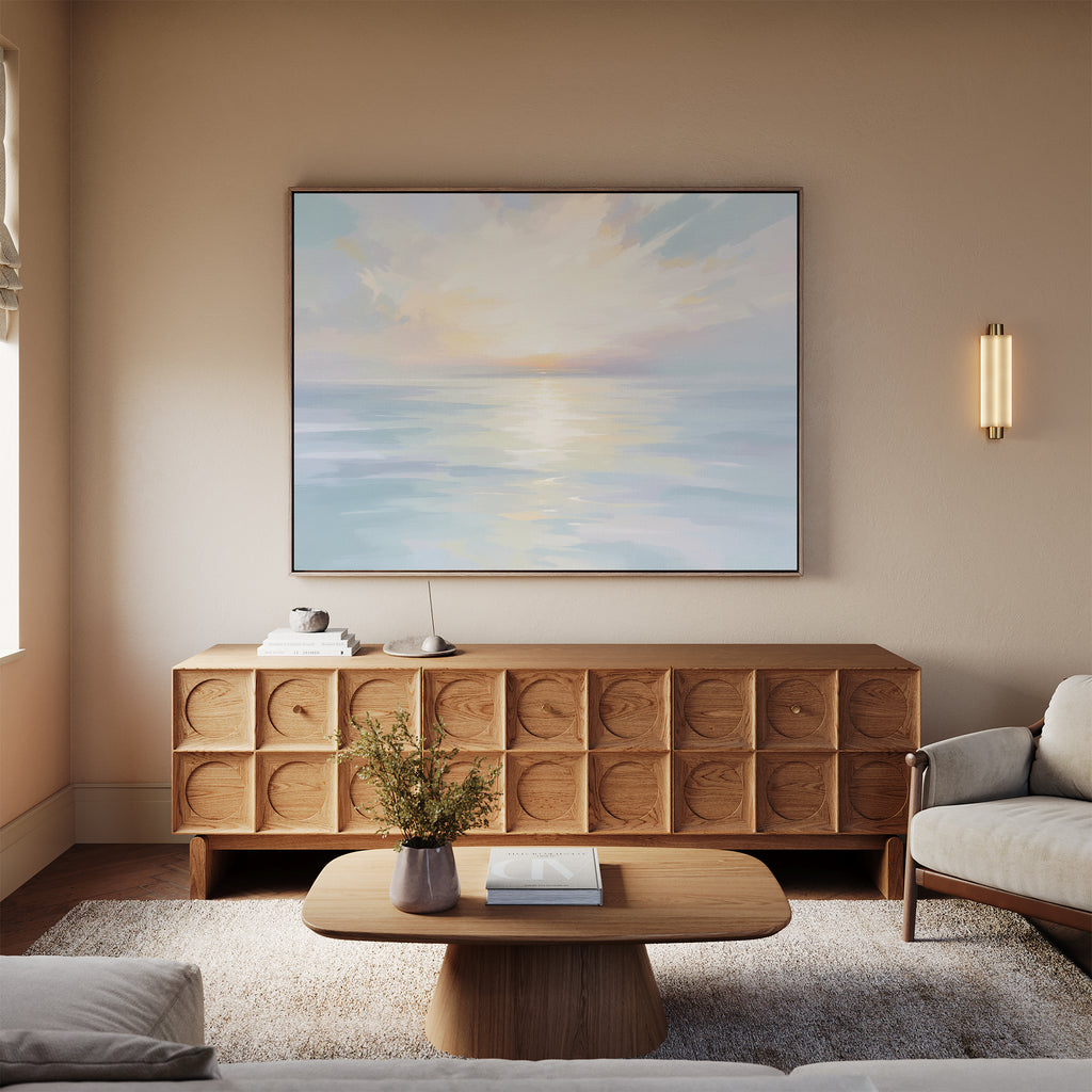 A cozy living room in neutral tones features a light wood coffee table, patterned wood sideboard, and the "Ethereal Waters Canvas Art - Horizontal" above a beige sofa. A soft rug and vase of flowers complete the inviting space.