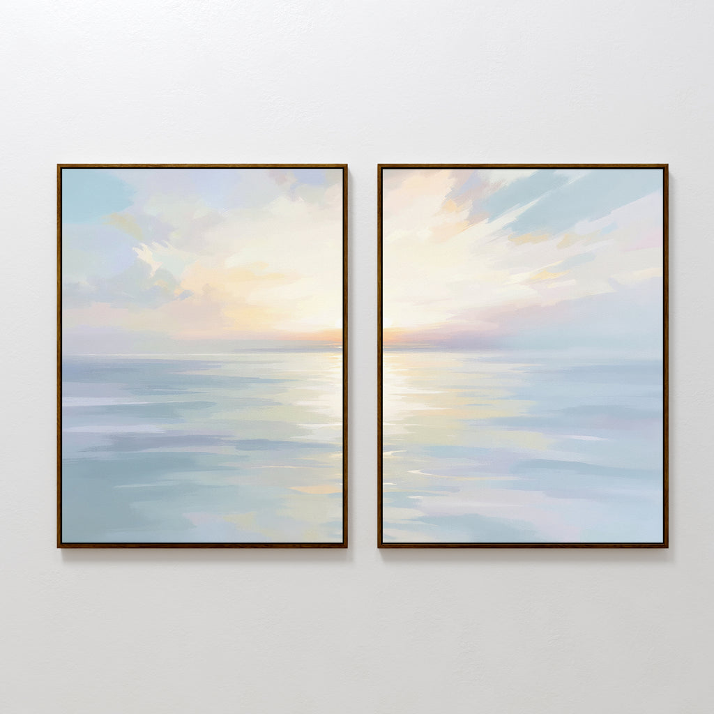 The "Ethereal Waters - Set of 2" features framed canvas prints of a calm ocean at sunrise or sunset, with pastel skies and soft reflections. This serene wall art duo is shown side by side on a plain white wall.