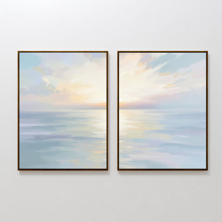 The "Ethereal Waters - Set of 2" features framed canvas prints of a calm ocean at sunrise or sunset, with pastel skies and soft reflections. This serene wall art duo is shown side by side on a plain white wall.