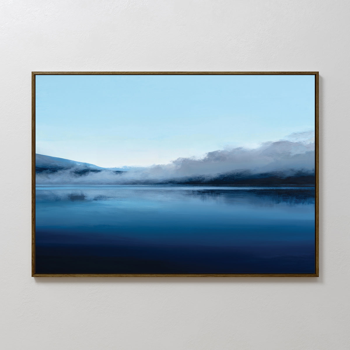 The Fjord Mist Canvas Art - Horizontal features a peaceful lake, calm blue water, misty mountains, and a pale sky—ideal for bringing serene, tranquil decor to any plain white wall.
