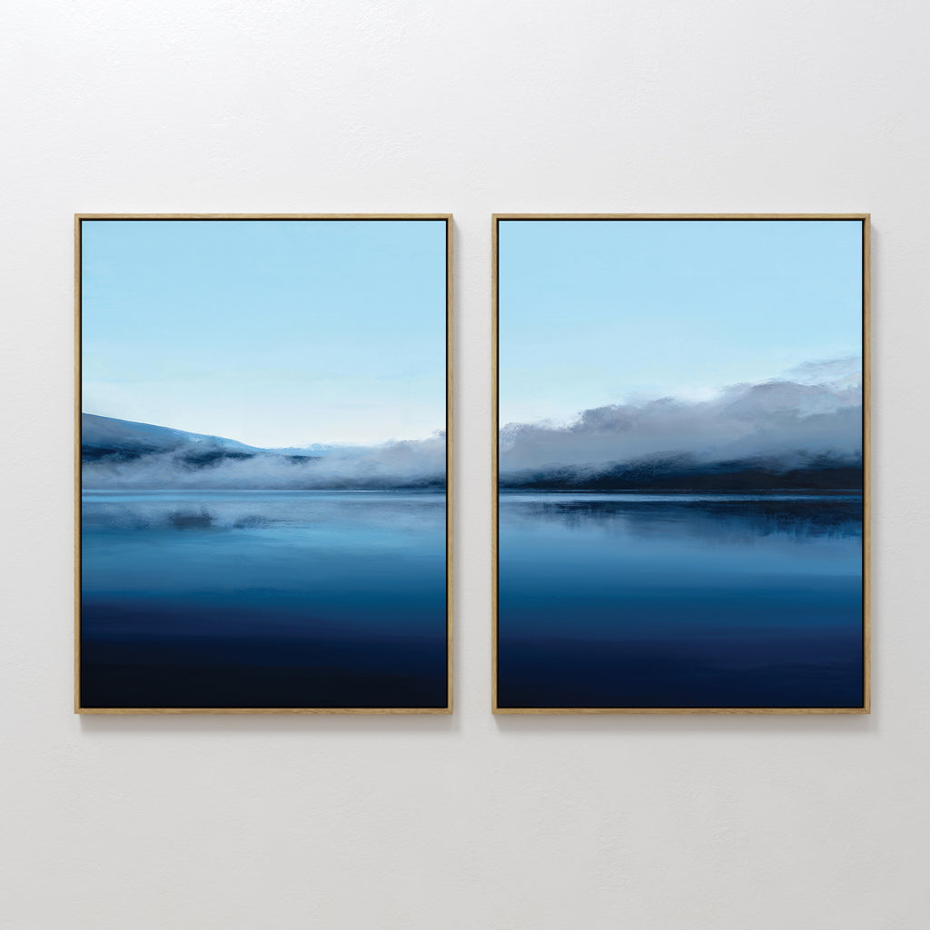 Fjord Mist - Set Of 2 features framed prints of serene blue waters, misty mountains, and a pale sky, bringing a peaceful minimalist Nordic Park vibe to your space.