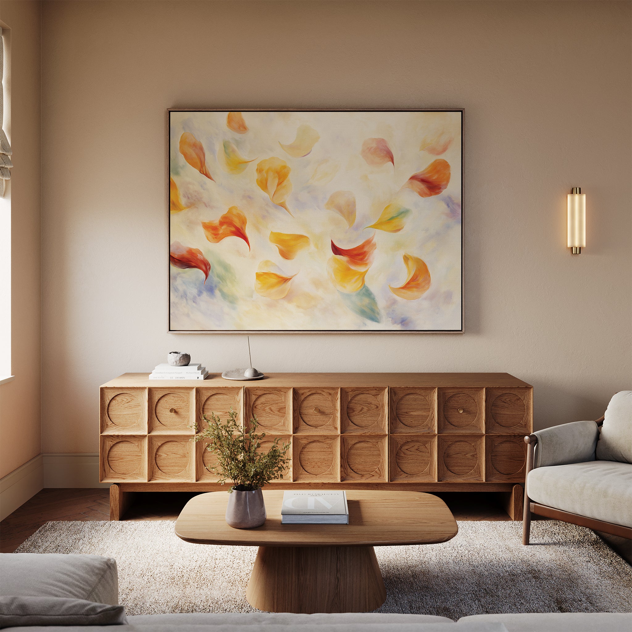 A modern living room with a wooden sideboard, a coffee table with a vase, a light sofa, and the Floating Petals Canvas Art - Horizontal above the sideboard brings organic elegance with its yellow and orange floating petals.