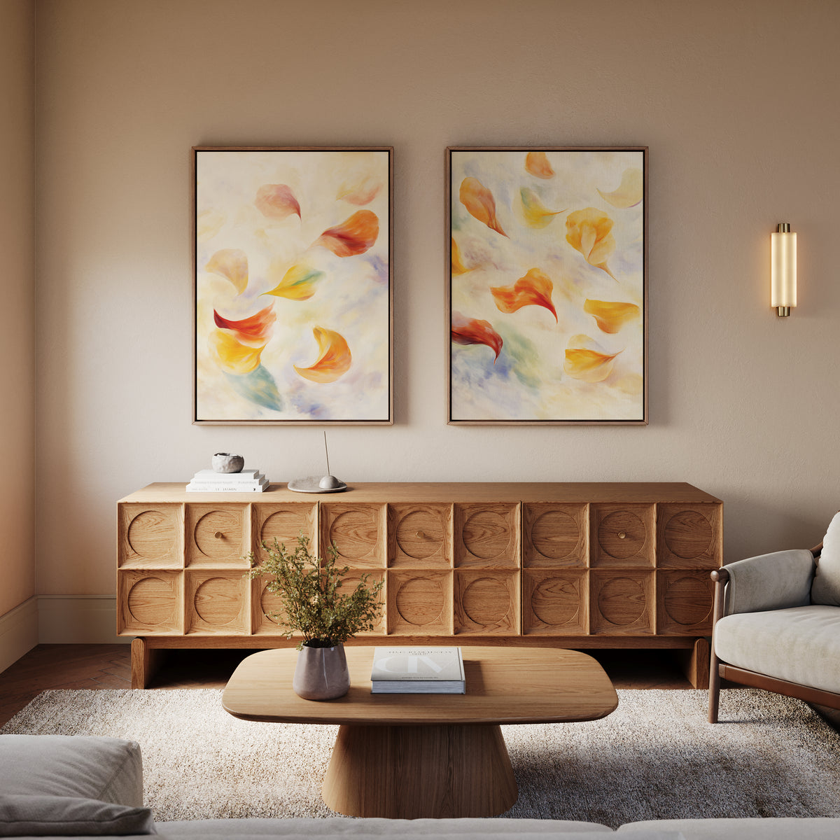 A minimalist living room features a wooden coffee table and sideboard, "Floating Petals - Set of 2" canvas prints, a small lamp, stacked books, a vase plant, and a light gray sofa for organic elegance.