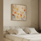 A cozy, minimal bedroom with a beige upholstered bed and white bedding. Above the headboard hangs the Floating Petals Canvas Art - Square, adding colorful, swirling elegance. Soft light filters through right-side curtains for an organic touch.
