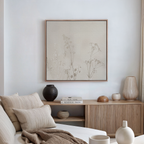 A minimalist living room with a neutral palette, showcasing a beige sofa with cushions, a wooden sideboard displaying vases and books, and the Floral Symphony Abstract Canvas Art as the centerpiece on the white wall.
