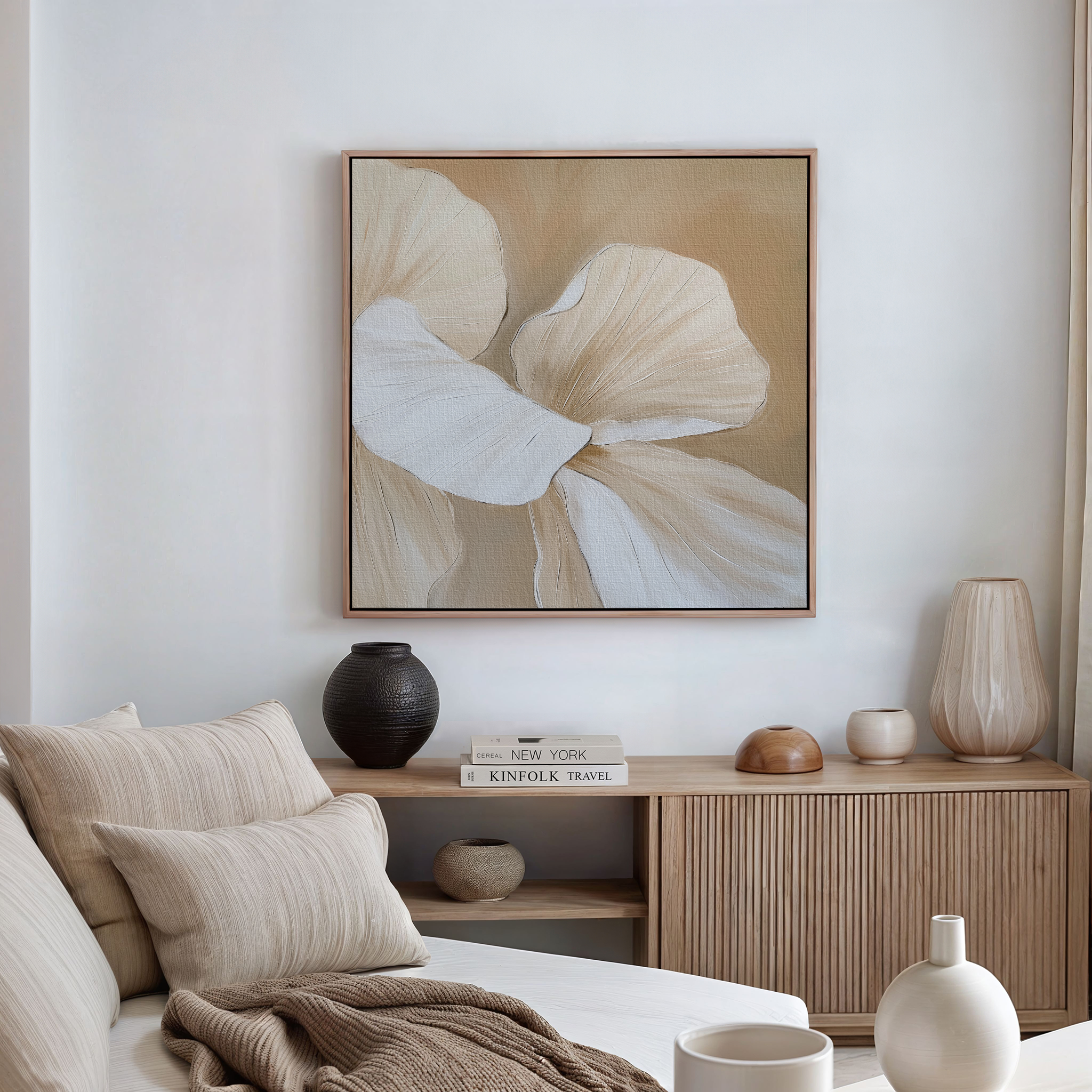 A modern, minimalist living room featuring a beige sofa, neutral cushions, wooden console table, decorative vases, books, and the Floral Whisper Abstract Canvas Art in beige and white tones hanging on the wall.