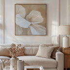 A neutral-toned living room with a beige sofa, tan and cream cushions, a side table with a white lamp, dried flowers in a vase, and the Floral Whisper Abstract Canvas Art in soft beige and white tones on the wall.