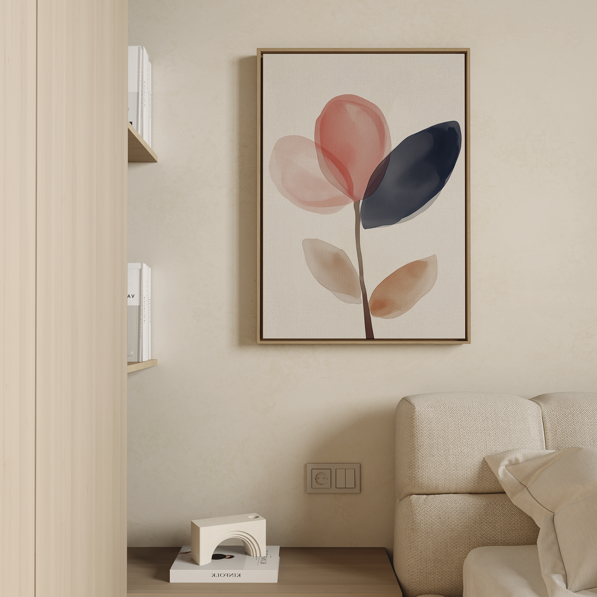 A minimalist living room featuring a beige couch and the Petal Breeze Canvas Art—abstract red, navy, and beige leaves—on the wall, with wooden shelves of books and a small white floor lamp for stylish decor.