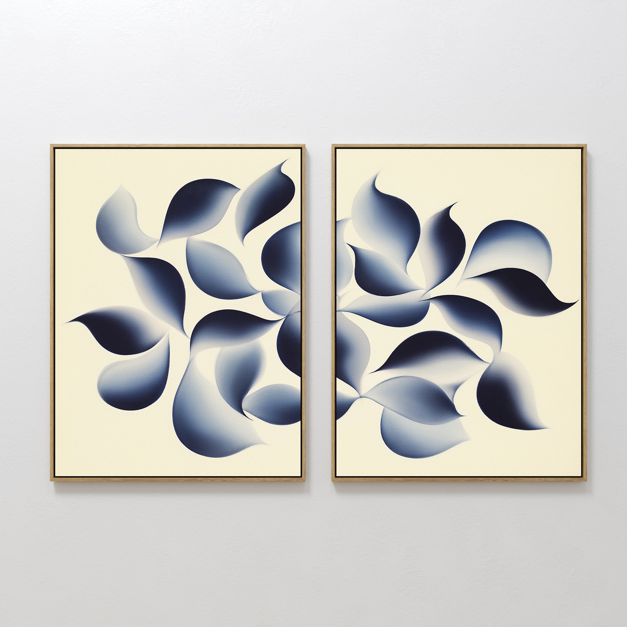 Flowing Shadows - Set of 2 showcases abstract framed canvas prints with leaf-like shapes in deep indigo on a cream background, creating dynamic and modern wall art ideal for contemporary living room decor.