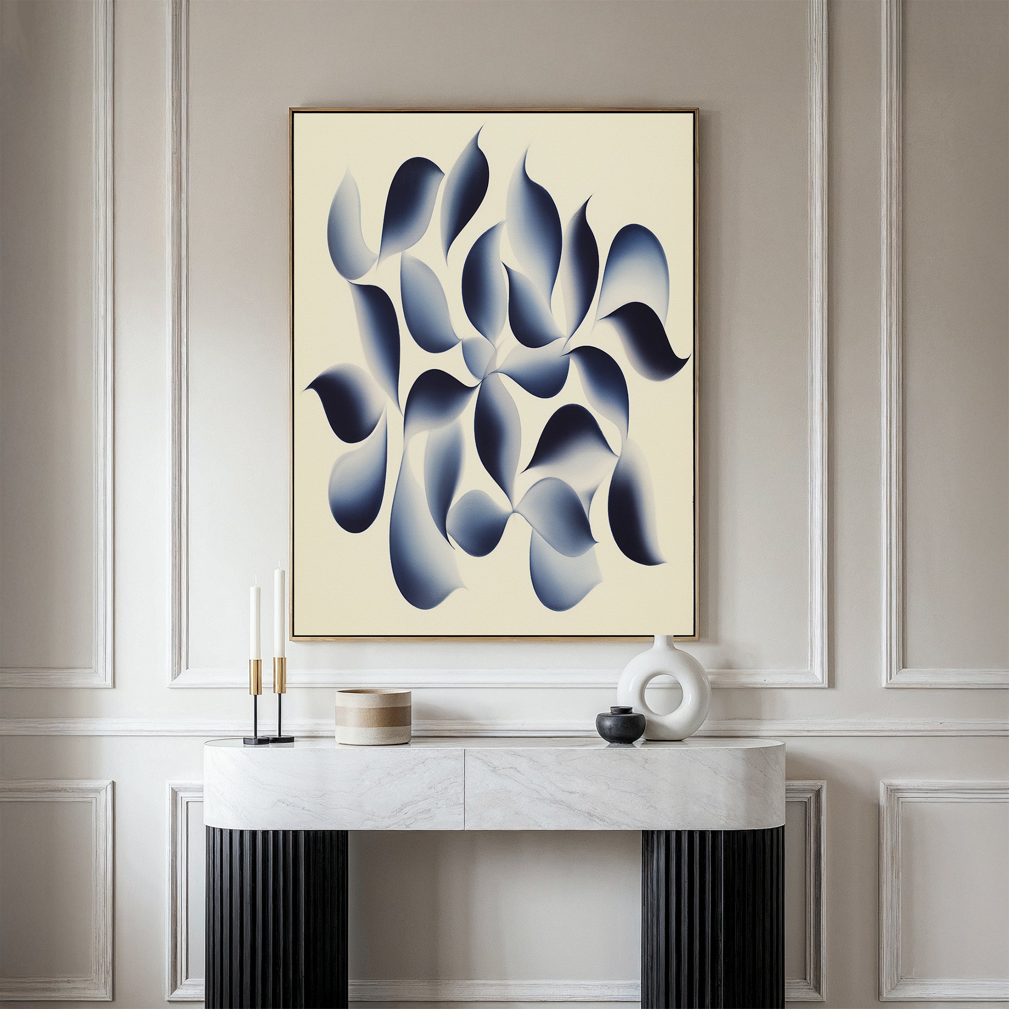 A minimalist room with a marble console table, decorative accents, and the "Flowing Shadows Canvas Art - Vertical"—a large abstract print with blue and gray curves on a light background—mounted on a paneled wall, showcases modern living room decor.