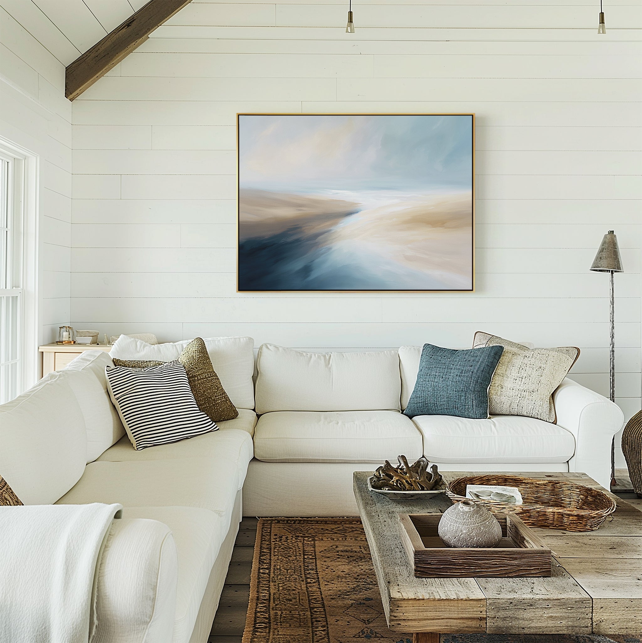 A bright living room with white shiplap walls, a large white sectional sofa, mixed throw pillows, rustic wooden coffee table, and the Fluid Motion Canvas Art - Horizontal above the couch creates a relaxing coastal vibe.