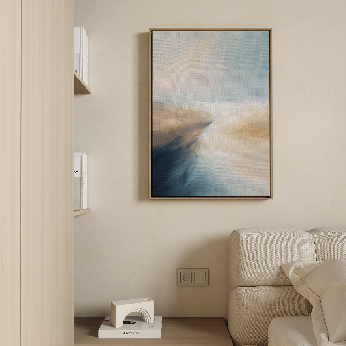 The Fluid Motion Canvas Art - Vertical in soft teal and sandy beige tones hangs on a cream wall above a beige sofa, next to minimalist wood shelves—perfect for modern living room decor.