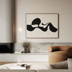 A modern living room with a beige sofa, stone accents, a low table with books and candles, and Fluid Forms Abstract Canvas Art in black and white above the sofa; a vase with dried flowers sits on a shelf.