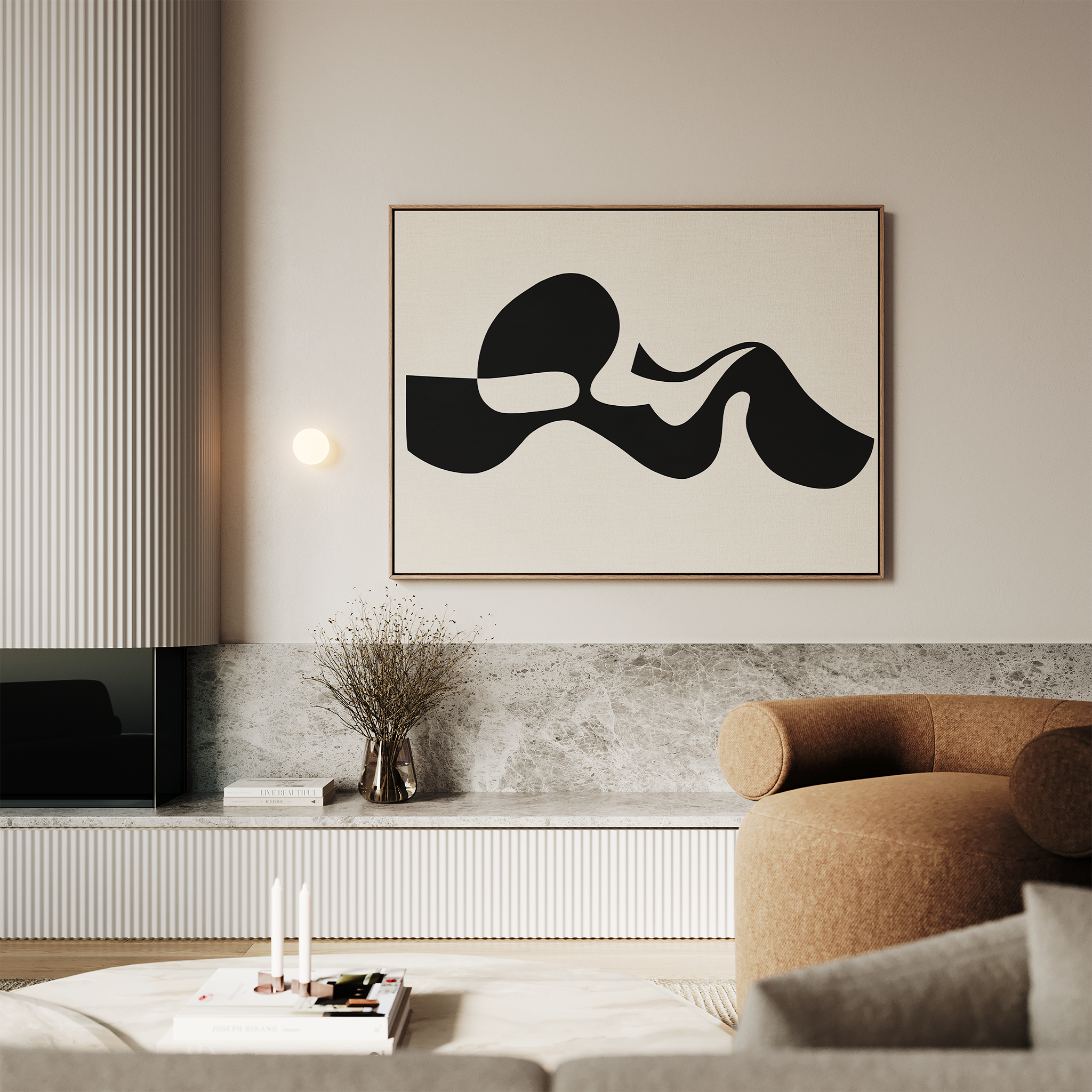 A modern living room with a beige sofa, stone accents, a low table with books and candles, and Fluid Forms Abstract Canvas Art in black and white above the sofa; a vase with dried flowers sits on a shelf.