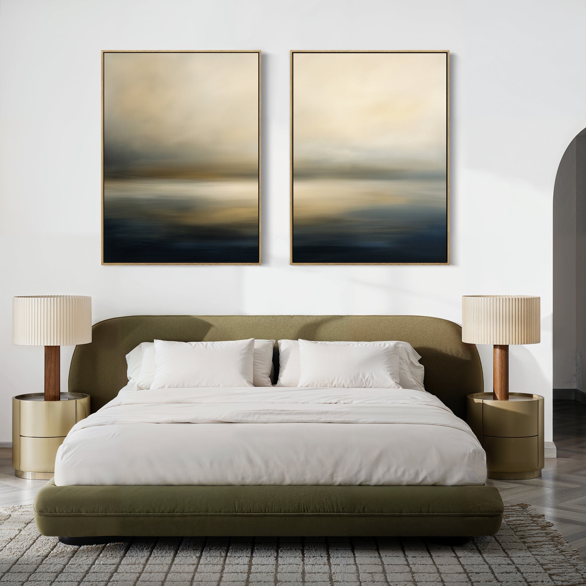 A modern bedroom with a low olive-green bed, white bedding, two round gold nightstands with beige lamps, and "Foggy Bay Impressions - Set Of 2" abstract wall art in neutral tones hanging above the bed.
