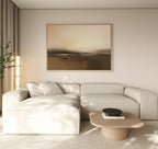 A modern living room with a cream sectional, light wood coffee table, black bowl, floor lamp, potted plant, and the Foggy Beach Expanse Canvas Art - Horizontal adding serene, neutral tones to the beige wall.