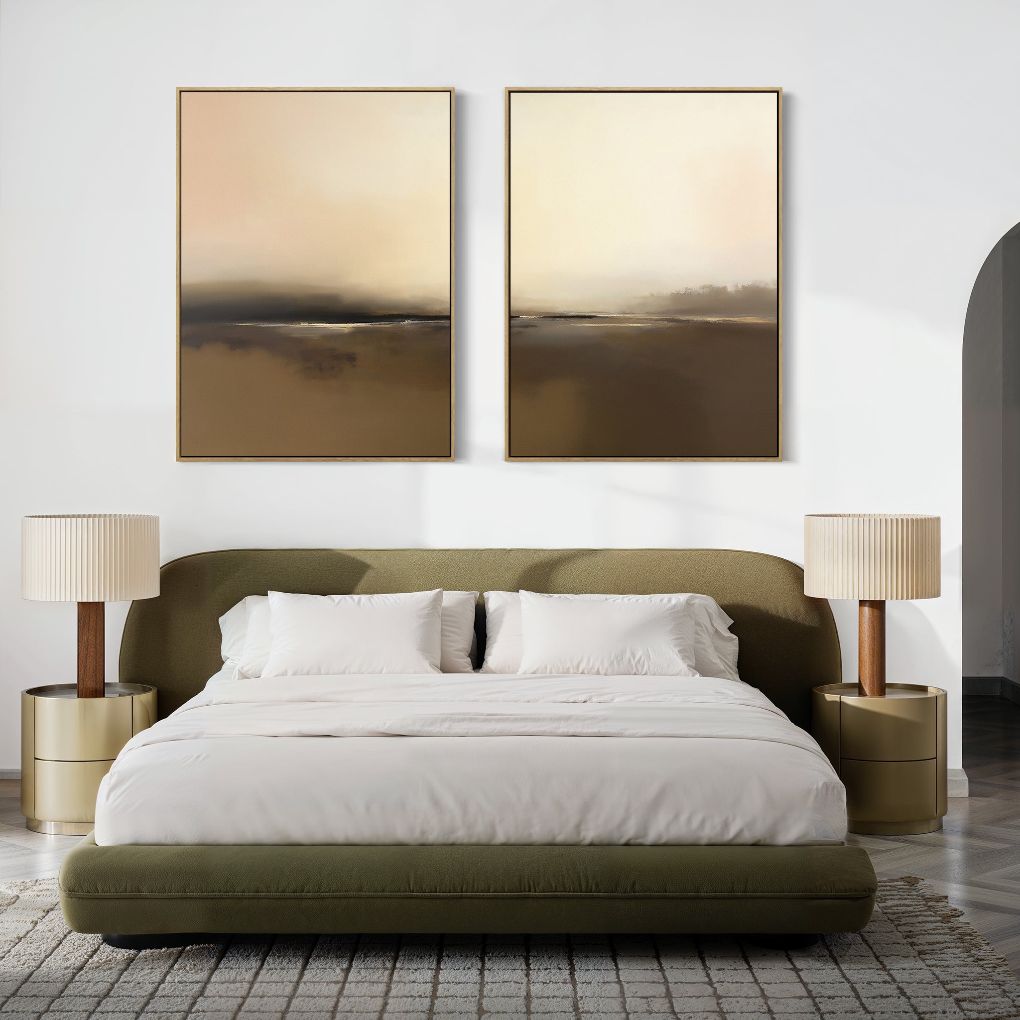 A modern bedroom features a green upholstered bed with white bedding, two round gold nightstands and pleated lamps, accented by the "Foggy Beach Expanse - Set Of 2" abstract paintings in soft neutral tones above the bed.