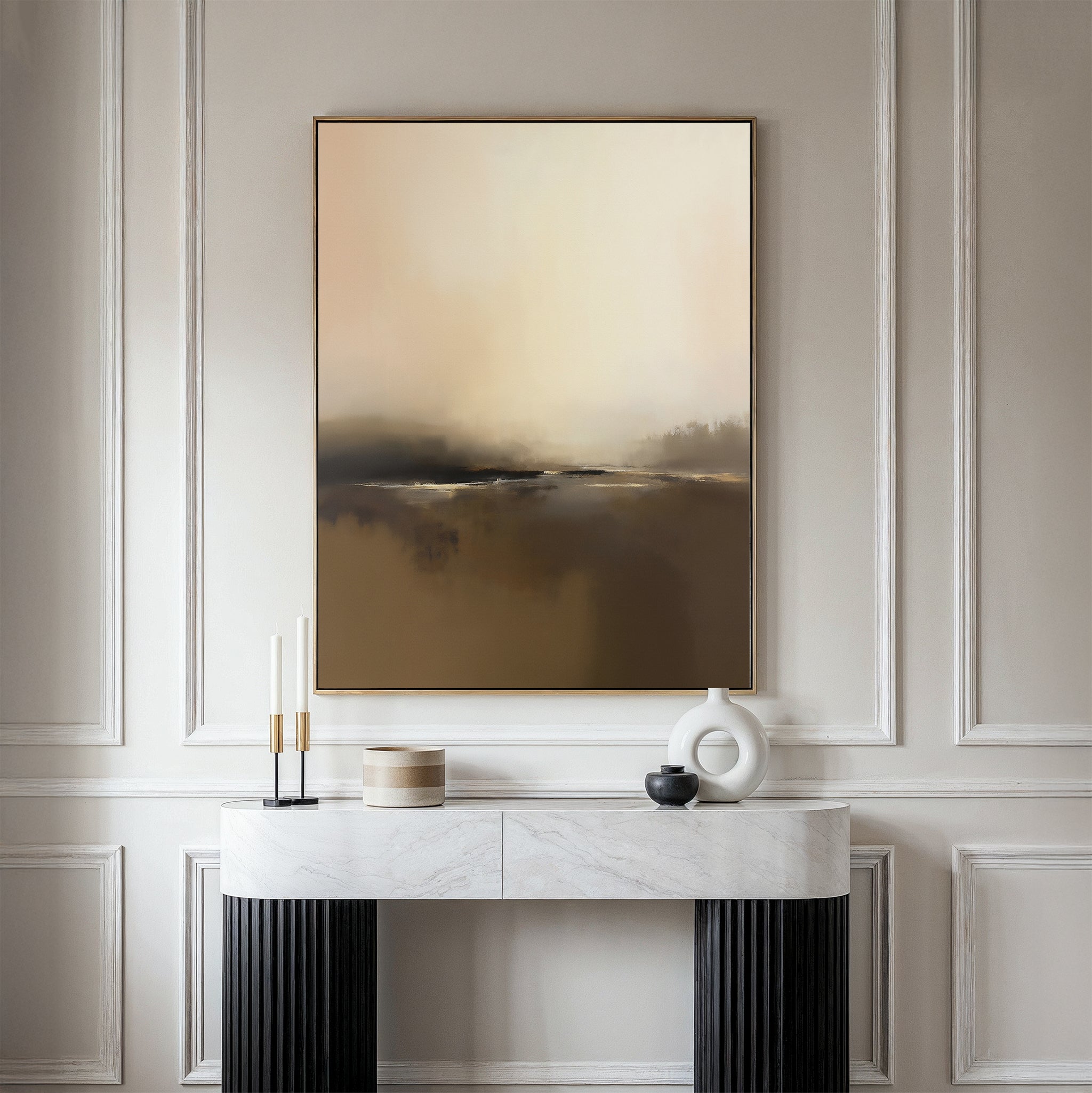 A modern console table with decor accents sits against elegant white paneling, beneath the Foggy Beach Expanse Canvas Art - Vertical in warm beige and brown tones.