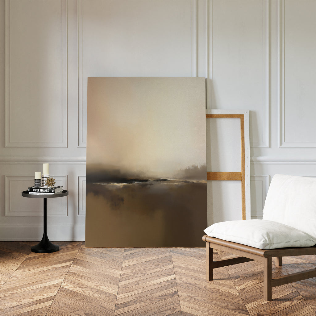 A minimalist room with herringbone wood floors, white paneled walls, a cushioned wooden chair, a small black round table with candles, and the Foggy Beach Expanse Canvas Art - Vertical propped against the wall.