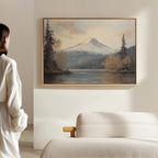 A person stands in a minimal, light-filled room, admiring the Frosted Ascent Canvas Art - Horizontal, which captures tranquil Nordic Park beauty and is displayed above a beige sofa.