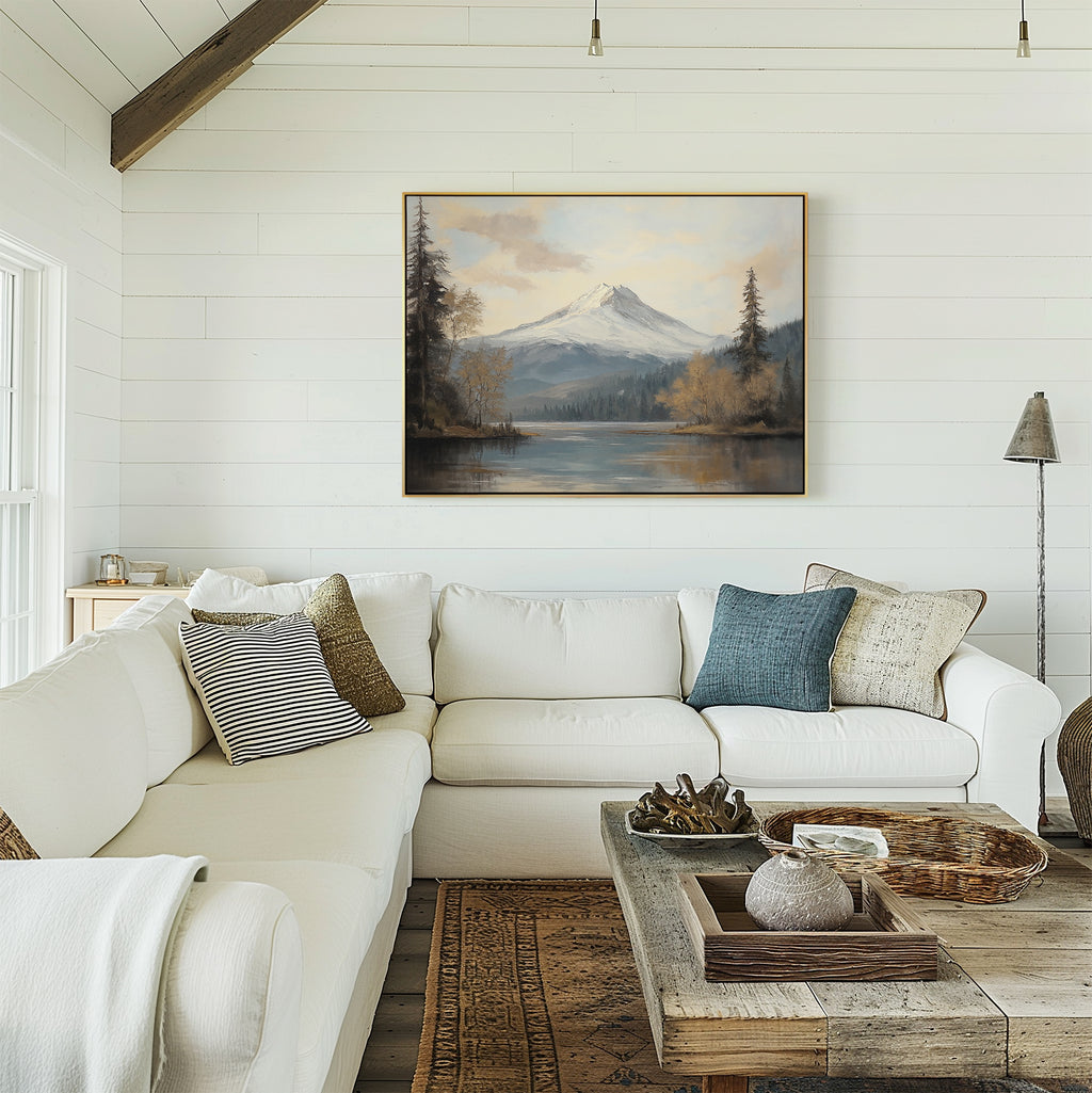 A cozy living room with white couches, textured pillows, and a rustic wooden coffee table features the Frosted Ascent Canvas Art - Horizontal on a white shiplap wall, capturing tranquil mountain beauty as natural light fills the space.