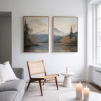 A modern living room with a light gray sofa, woven chair, and candles is enhanced by “Frosted Ascent - Set of 2” mountain lake canvas prints above the seating, infusing peaceful Nordic Park vibes into the space.