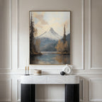 The Frosted Ascent Canvas Art - Vertical, featuring a snow-capped mountain, pine trees, and a lake, is framed and displayed above a modern marble console with decorative objects and candles on a beige wall.